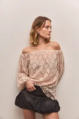 Blusa de encaje color rosa pálido, con hombros descubiertos y mangas largas.