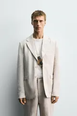Blazer azul marino de lino, corte regular fit, con solapas de muesca, cierre de dos botones, bolsillo de vivo en el pecho, bolsillos de solapa en la cadera, aberturas en la espalda y puños con botones.