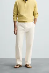Pantalón chino color crema, de corte recto y largo a la altura del tobillo.
