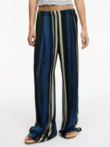 Pantalón de tiro alto con estampado a rayas verticales en tonos rojo, azul, marrón y beige. Tiene bolsillos laterales ocultos y corte amplio.