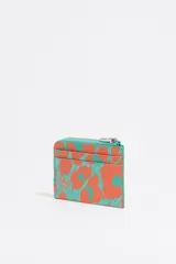 Monedero pequeño con estampado abstracto en tonos naranja y turquesa, con cierre de cremallera y logo metálico de la marca Bimba y Lola.