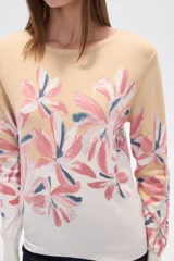 Sweater de tejido de punto, color crema, con estampado floral en tonos rosados y marrones. Presenta cuello redondo y mangas largas.