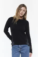 Sweater negro de hilado de lana con alpaca, de calce clásico, escote a la base y manga larga, con detalles de encaje en las mangas y el ruedo.