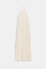 Vestido largo color blanco roto o crema, con textura plisada o arrugada verticalmente. Presenta un cuello halter que se ata en la nuca y espalda descubierta.