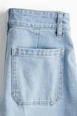 Pantalón de jean celeste de pierna ancha, tiro alto, con bolsillos de parche delanteros y traseros.