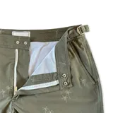 Short de baño verde militar con estampado de palmeras, pretina fija con hebillas metálicas laterales, botón a presión, cierre frontal, tres bolsillos (dos laterales y uno trasero), tela con spandex de secado rápido e interior de mesh hipoalergénico.
