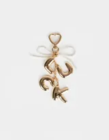 Llavero con dije de letras doradas que forman la palabra "LUCK" y cinta de perlas sintéticas.