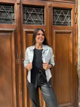 Chaqueta plateada metalizada con cuello camisero, cierre frontal con botones, bolsillos de parche en el pecho y corte recto.