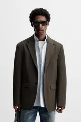 Blazer straight fit color marrón oscuro con finas rayas verticales claras. Confeccionado en tejido con lana de origen italiano. Cuello con solapas de muesca y manga larga acabada en puño con botones. Bolsillos de vivo en pecho y de solapa en cadera. Detalle de bolsillo interior. Bajo con aberturas en espalda. Cierre frontal de botonadura.