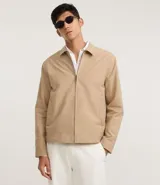 Campera masculina color marrón confeccionada en sarga, con cuello inglés, cierre de cremallera frontal, manga larga y bolsillos con detalles.