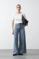 Remera de manga corta color beige claro, confeccionada en tejido acanalado elástico, con cuello redondo.