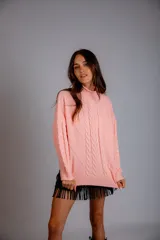 Sweater color crudo con cuello alto y diseño trenzado.