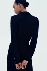 Vestido camisero midi negro de viscosa con cuello camisero, botonadura frontal, cinturón ancho extraíble para atar, mangas raglán largas con puños abotonados y sin forro.