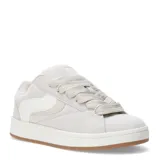 Zapatillas deportivas color beige con cordones gruesos y suela de goma color caramelo.
