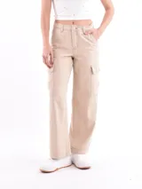 Pantalón cargo de mujer color beige claro, tiro medio/alto, corte ancho y recto, con bolsillos laterales tipo parche en las piernas.