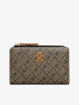 Billetera plegable Tommy Hilfiger con estampado de monograma en tonos marrones y negros. Cuenta con múltiples ranuras para tarjetas, compartimento para billetes y bolsillo exterior con cremallera para monedas.