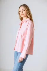 Camisa rosada a rayas verticales, de corte holgado y manga larga.