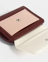 Billetera colorblock de cuerina con solapa con broche a presión, cierre y tirador.