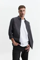 Camisa de manga larga gris oscuro, corte slim, con cartera abotonada, dos bolsillos frontales con botón y confeccionada en 100% algodón.