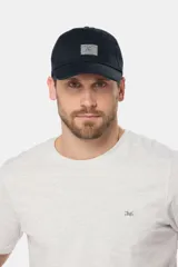 Gorra de béisbol azul marino confeccionada en lona de algodón, con visera curva y parche rectangular con logo en el frente.