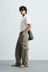 Pantalón cargo de algodón color verde oliva, corte regular fit, con bolsillos laterales con fuelle y solapa, y efecto lavado.