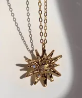 Collar con cadena fina negra y dije de estrella plateada con incrustaciones de strass.