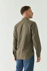 Camisa de gabardina gris con corte slim, mangas largas, cartera abotonada y dos bolsillos con solapa en el pecho.