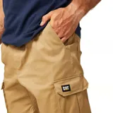 Pantalón cargo color beige de corte slim, con cintura elástica ajustable con cordón, bolsillos laterales tipo cargo con solapa, bolsillo trasero para herramientas y puños elásticos en los tobillos. Confeccionado en tejido ligero de mezcla de algodón y spandex.