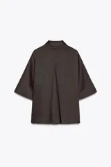 Camisa marrón de corte recto, con cuello solapa, manga corta y cierre frontal con botones.