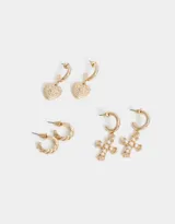Set de aros dorados que incluye dos argollas pequeñas con diseño torzado, dos argollas con dije de cruz con perlas y dos argollas con dije de corazón con diseño floral.