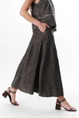 Falda larga de lino a cuadros grises y blancos, con corte al bies y cintura alta.