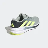 Championes de running Adidas Questar 3, color gris claro con tres franjas laterales en amarillo neón. Presentan detalles en azul oscuro en el talón y la suela, con entresuela blanca y tecnología Cloudfoam Plus.