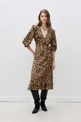 Vestido midi de viscosa con estampado animal print, escote en V cruzado con volados, mangas 3/4 con volados en los hombros, corte a la cintura con cinturón negro con aplique de flor y volados en el ruedo.