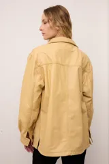 Chaquetón de cuero negro oversized, con corte recto y bolsillos delanteros. Presenta un bordado en los bolsillos inspirado en la costa atlántica.