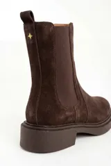 Bota tipo Chelsea de gamuza color marrón oscuro, con paneles elásticos laterales al tono, tirador trasero y suela de goma robusta con vira pespunteada.