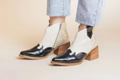 Botas de cuero con diseño bicolor, combinando negro y blanco, con tacón bajo.
