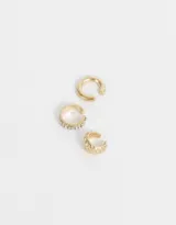 Set de tres earcuffs dorados de metal, uno liso, uno con strass y uno con diseño trenzado.
