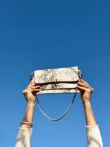 Cartera mini bag con estampado animal print, con cierre dorado y correa fina al hombro.