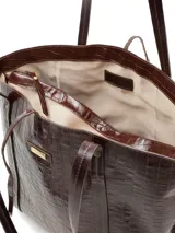Cartera shopper grande de cuero marrón con textura tipo cocodrilo, doble asa de hombro y cierre superior con lazo.