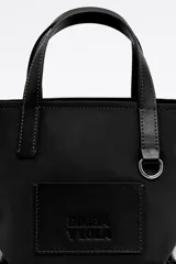 Bolso shopper mini Bimba y Lola de nailon negro con estructura blanda, doble asa de mano y asa de tejido, piezas de piel, logo grabado, acabados metálicos en plateado y cierre de cremallera.