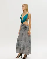 Vestido largo de corte irregular, con escote halter y espalda descubierta. La parte superior es de color turquesa y la falda es de color gris con estampado abstracto.