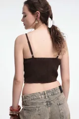 Top negro con breteles finos, escote en V y abotonadura frontal.