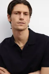 Remera polo negra de piqué de algodón, de corte estándar, con cuello clásico, tapeta de botones, mangas cortas y remate acanalado en cuello y mangas.