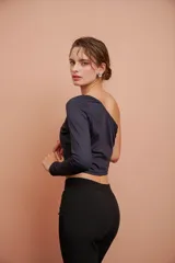 Top corto negro de un hombro con manga larga ajustada.