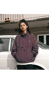 Chaqueta tipo anorak impermeable de color negro, con cuello alto y cierre parcial frontal. Presenta un pequeño logo en el pecho y ajuste regulable en la cintura para un calce más holgado o ceñido.