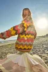 Cárdigan tejido a mano en 100% lana con diseño en zigzag y cierre frontal.