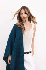 Ruana tejida en lana merino color amarillo pastel, con terminación de flecos.