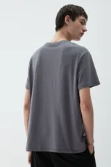 Remera gris de corte estándar, con cuello redondo ribeteado y bajo recto. Confeccionada con tejido funcional COOLMAX®, una fibra exclusiva de poliéster de secado rápido que elimina la humedad y regula la temperatura corporal.