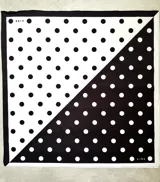 Pañuelo cuadrado blanco con estampado de lunares negros.