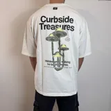 Remera blanca de corte oversize con estampa de hongos y texto en la espalda.